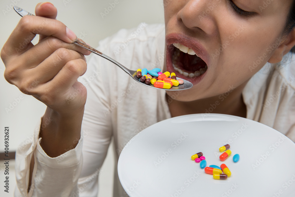 Crazy women eating many pills in spoon. Crazy women eating many pills in spoon.