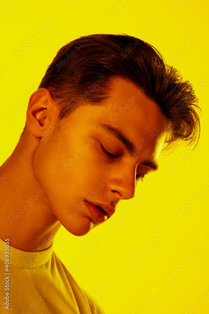 Sunny. Handsome caucasian man's portrait isolated on orange studio background in neon, monochrome. Beautiful male model. Concept of human emotions, facial expression, sales, ad, fashion and beauty. Sunny. Handsome caucasian man's portrait isolated on orange studio background in neon, monochrome. Beautiful male model. Concept of human emotions, facial expression, sales, ad, fashion and beauty.