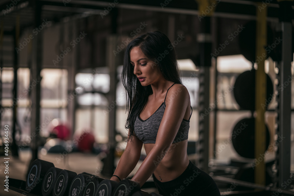 Fototapeta premium Young female in gym. Young woman working out. Girl in gym training hard.