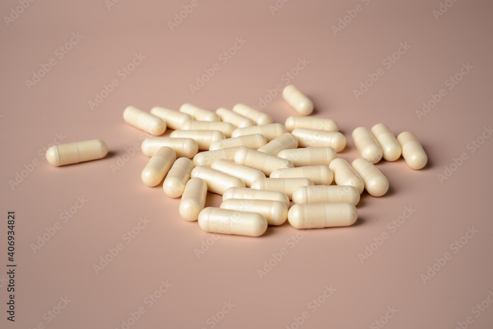 White capsules placed on a
beige background White capsules placed on a
beige background
