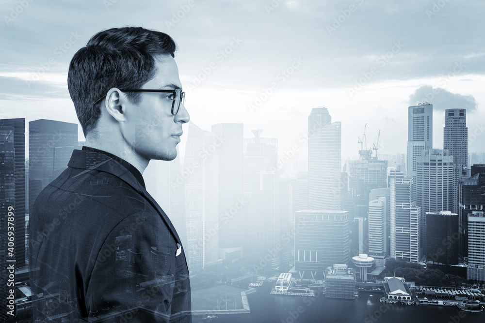 Young handsome businessman in suit and glasses dreaming about new career opportunities after MBA graduation. Singapore on background. Double exposure.