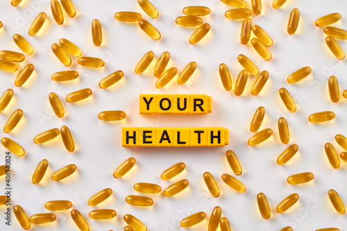 Your health plastic blocks. Yellow pill vitamins on white background.