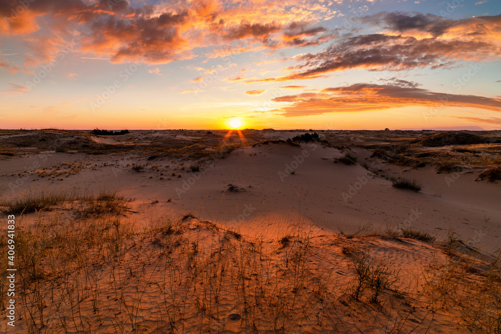 Sunset over the sand dunes in the desert. Arid landscape of the Sahara desert