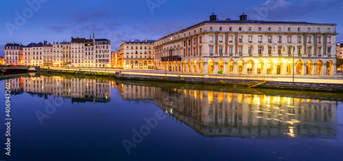 City of Bayonne in France at night with houses of typical architecture and reflections on the Adur River 