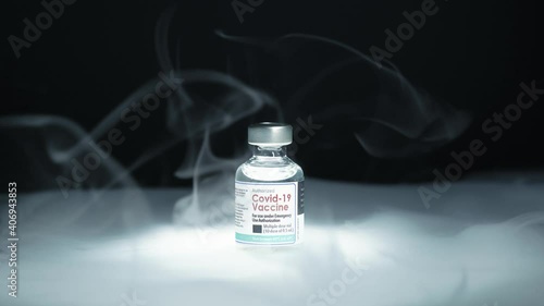 Covid 19 mRNA technology vaccine research and development. Close up of frozen cold vaccine vial stored in low temperature storage with flowing smoke. Thermal controlled for global distribution. photo