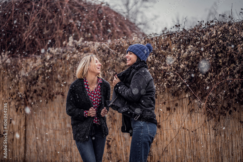 Two beautiful women on first snow this year. Gorgeous females enjoying snow outdoors. Winter photo snowing outside Two beautiful women on first snow this year. Gorgeous females enjoying snow outdoors. Winter photo snowing outside