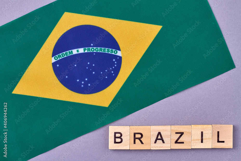 Obraz premium National flag of Brazil. Wooden alphabet blocks with letters isolated on violet background.