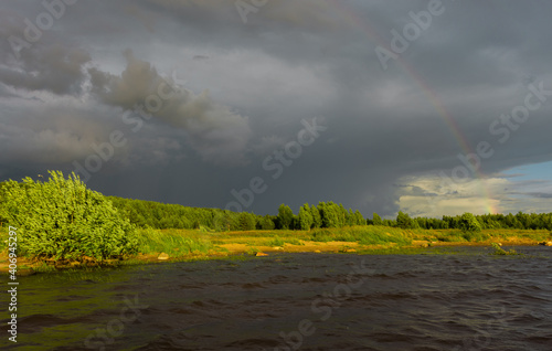 beautiful view of storm clouds and rainbows illuminated by a bright sunset