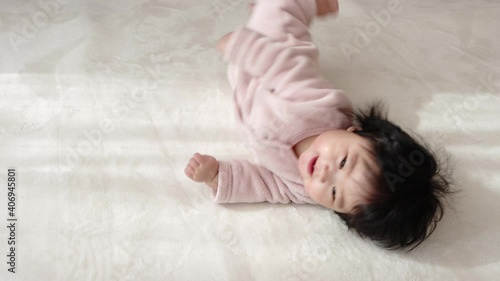 寝返りを失敗する赤ちゃん（0歳、生後6カ月、女の子、日本人）