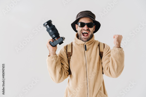 Delighted photographer showing winner gesture while posing with camera