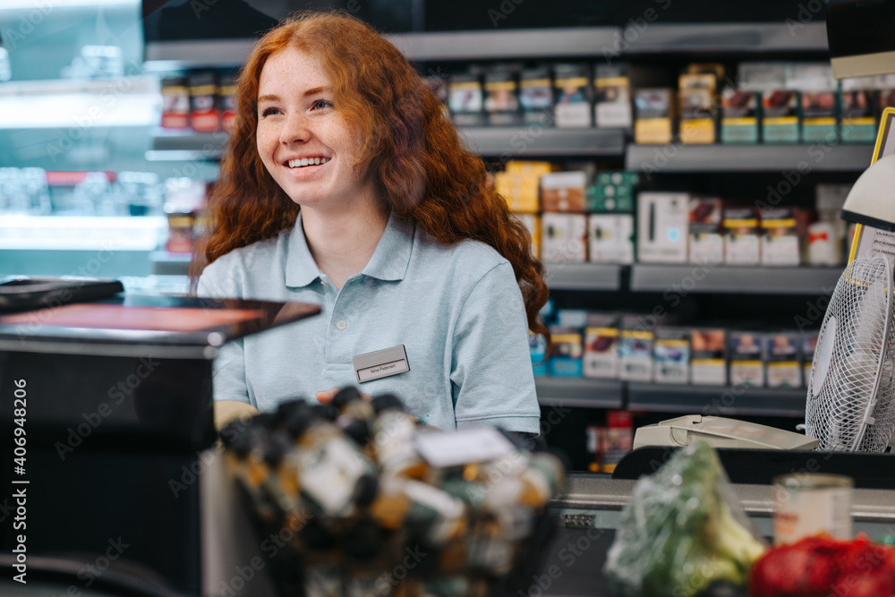 Woman working at supermarket checkout counter