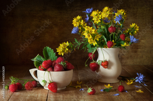 Still life with strawberries and wild flowers in a rustic style.