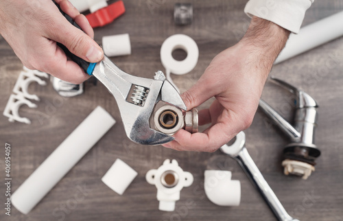 A plumber fixes a water faucet.