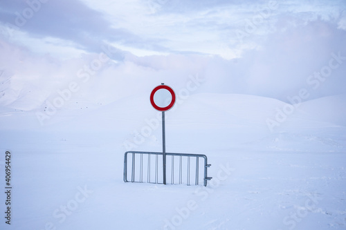  no entry or transit, on a snow-covered road, over one meter of snow. desolation and silence in an abandoned landscape.