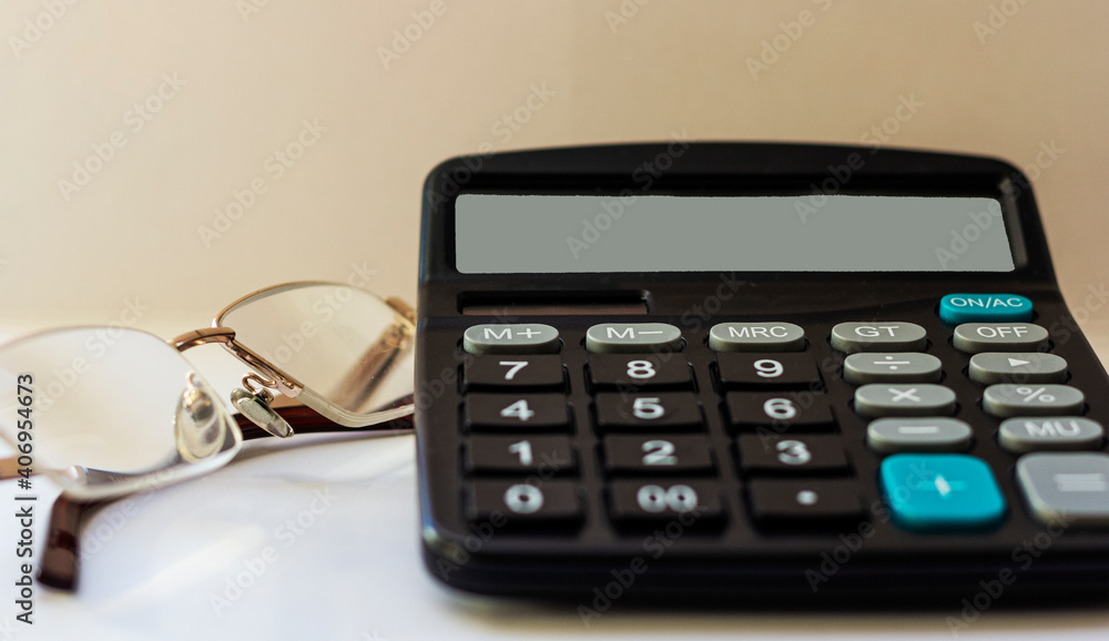 Glasses and calculator on white background, working desk of businessman Glasses and calculator on white background, working desk of businessman