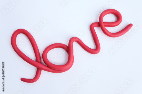 Word LOVE made from plasticine on white background.