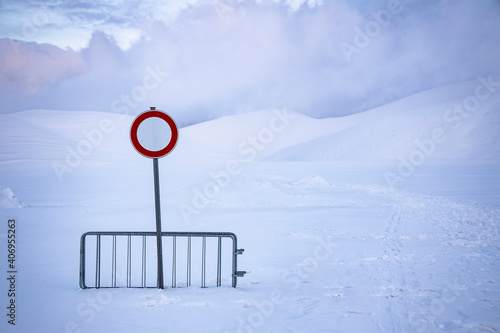 
no entry or transit, on a snow-covered road, over one meter of snow. desolation and silence in an abandoned landscape. photo