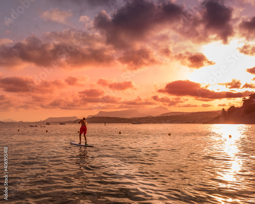 Person doing paddle surf in with a beautiful sunset on the beach