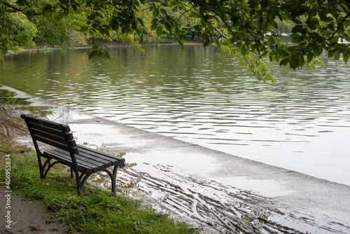 Empty bench by a walking trail and a pond © Mary Salen