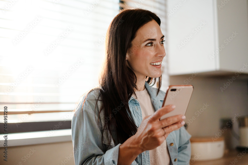 Smiling attractive young woman texting on mobile phone Smiling attractive young woman texting on mobile phone