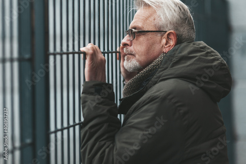 Desperate mature man near barrier in depression. Senior lonely introvert.