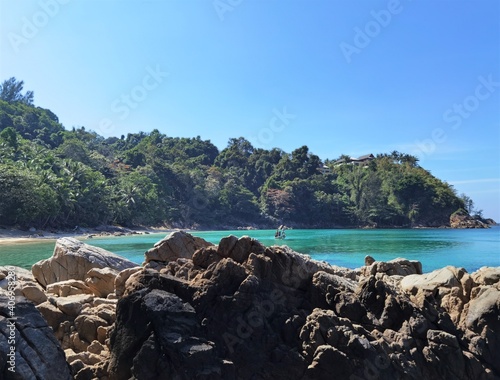 Green and blue water in lagoon around mountains and palm trees.