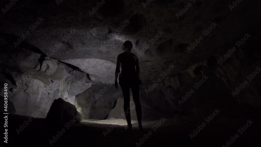 Female Tourist Exploring Cave With Flashlight Female Tourist Exploring Cave With Flashlight
