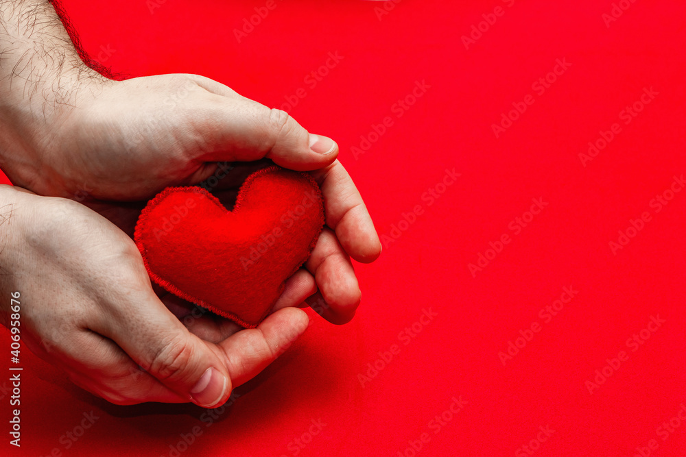 Fototapeta premium Male hands are holding a homemade felt heart