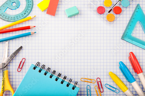 Accessories and school supplies for children's creativity of Trendy colors on  background of school writing-book in a cage.The concept of children's creativity and the concept 
