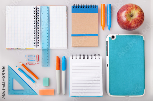 Children education, accessories, school supplies, colored pencils, an apple and a notebook on a white background. Schoolchildren study and creativity concept and back to school concept.