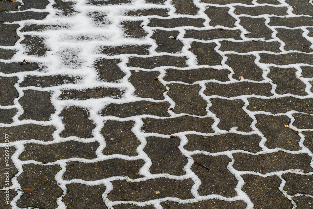 Winter sketch: white snowy pattern on the grey sidewalk Winter sketch: white snowy pattern on the grey sidewalk