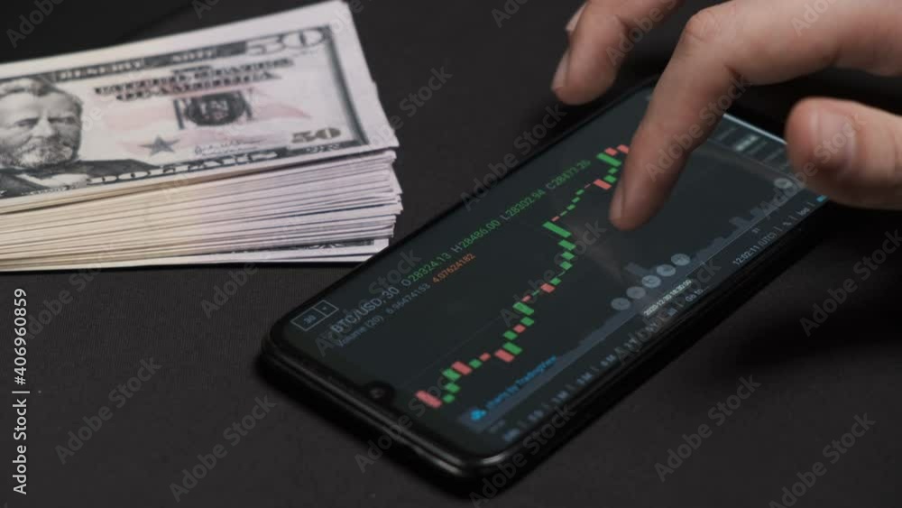 Businessman is checking Bitcoin price chart on digital exchange on mobile phone Businessman is checking Bitcoin price chart on digital exchange on mobile phone