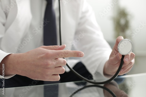 Doctor s hand finger points to stethoscope