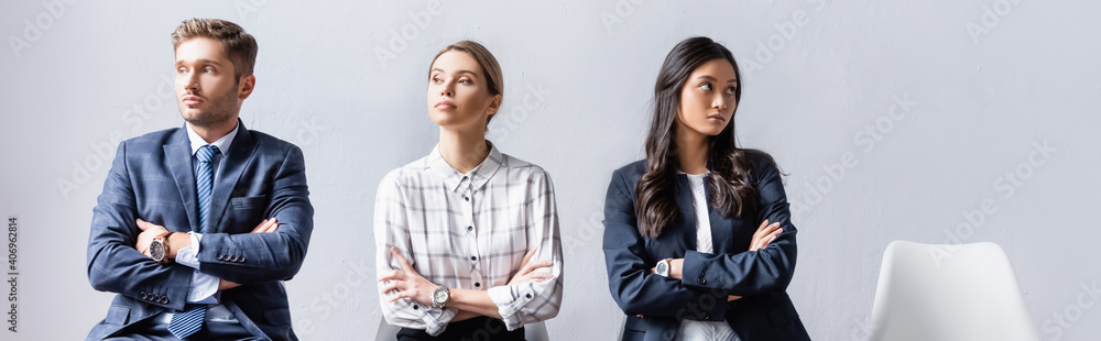Multiethnic business people sitting with crossed arms in hall, banner Multiethnic business people sitting with crossed arms in hall, banner