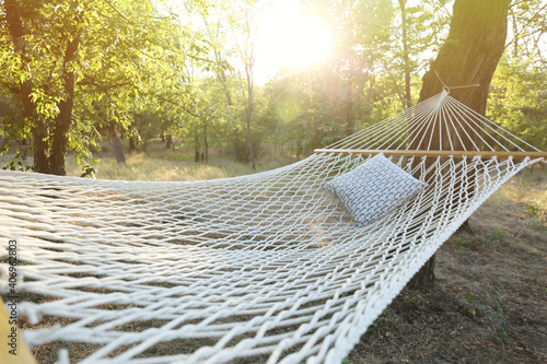 Fototapeta Naklejka Na Ścianę i Meble -  Comfortable net hammock with soft pillow at green garden, closeup