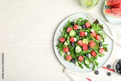 Delicious salad with watermelon served on white table, flat lay. Space for text
