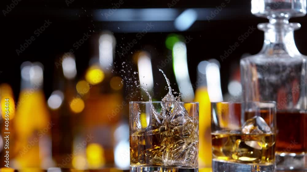 Super slow motion of falling ice cube into whiskey drink, camera motion. Filmed on high speed cinema camera, 1000 fps. Super slow motion of falling ice cube into whiskey drink, camera motion. Filmed on high speed cinema camera, 1000 fps.