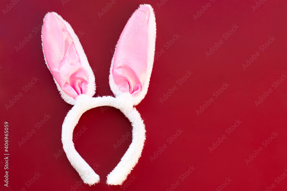 artificial white rabbit ears on a red background. easter holiday concept artificial white rabbit ears on a red background. easter holiday concept