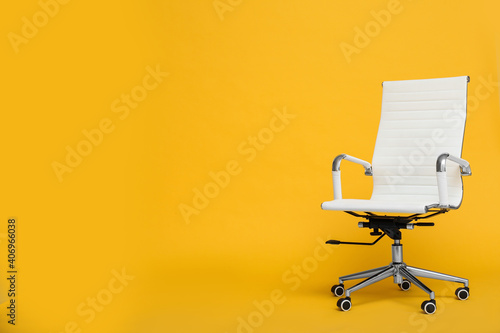 Modern office chair on yellow background. Space for text photo