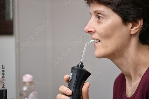 Portrait Of A Young Womanand and Professional Oral Irrigator photo