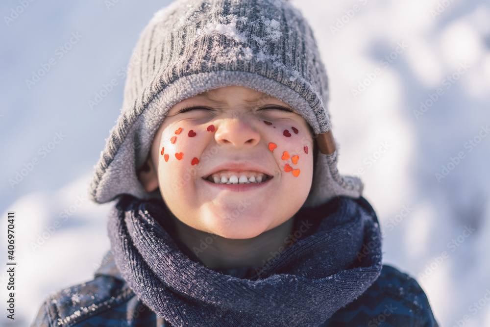 Joyful boy with red hearts on his face. Love concept Joyful boy with red hearts on his face. Love concept