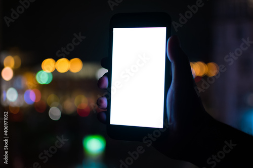 Close up of people holding cell phones against lighting at night