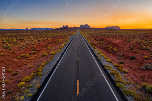 Highway road to the Monument Valley park. Amazing colorful sunset sky. Arizona, USA