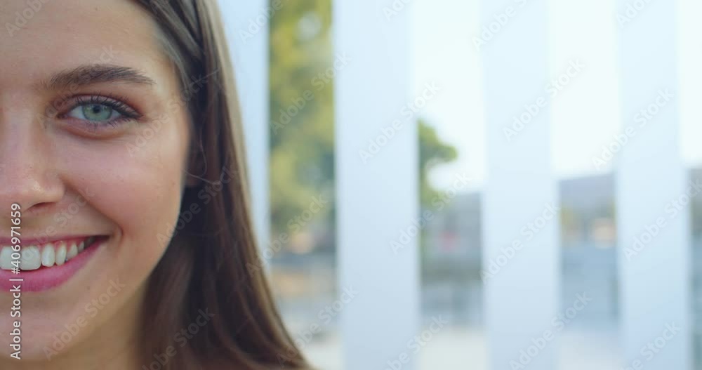 Portrait of joyful beautiful female with long hair and green eyes smiling at street. Close up of half face of pretty woman with happy smile outdoor at bus stop. Train station. Travel, tourism concept Portrait of joyful beautiful female with long hair and green eyes smiling at street. Close up of half face of pretty woman with happy smile outdoor at bus stop. Train station. Travel, tourism concept