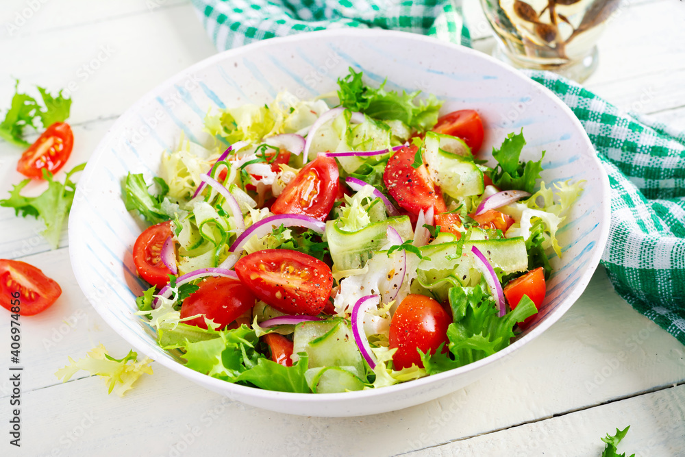 Fresh tomatoes with cucumber, lettuce, red onion and spices in a white bowl. Concept healthy appetizer. White wooden background. Fresh tomatoes with cucumber, lettuce, red onion and spices in a white bowl. Concept healthy appetizer. White wooden background.
