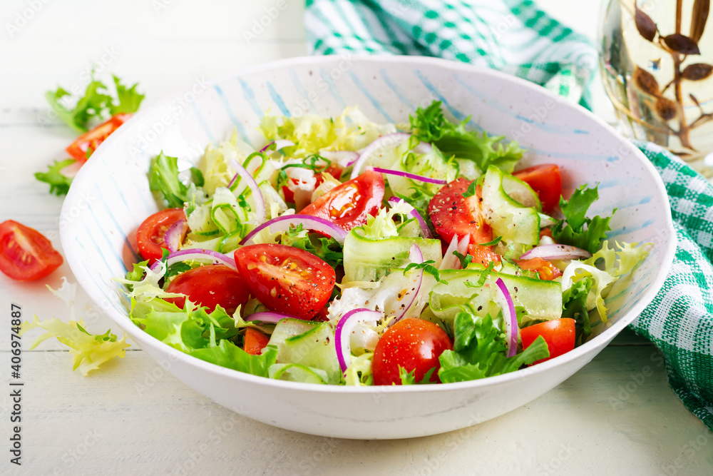 Fresh tomatoes with cucumber, lettuce, red onion and spices in a white bowl. Concept healthy appetizer. White wooden background. Fresh tomatoes with cucumber, lettuce, red onion and spices in a white bowl. Concept healthy appetizer. White wooden background.