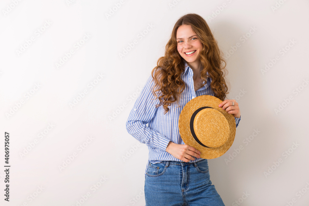 young beautiful stylish woman in summer style outfit posing on white wall wearing straw hat young beautiful stylish woman in summer style outfit posing on white wall wearing straw hat