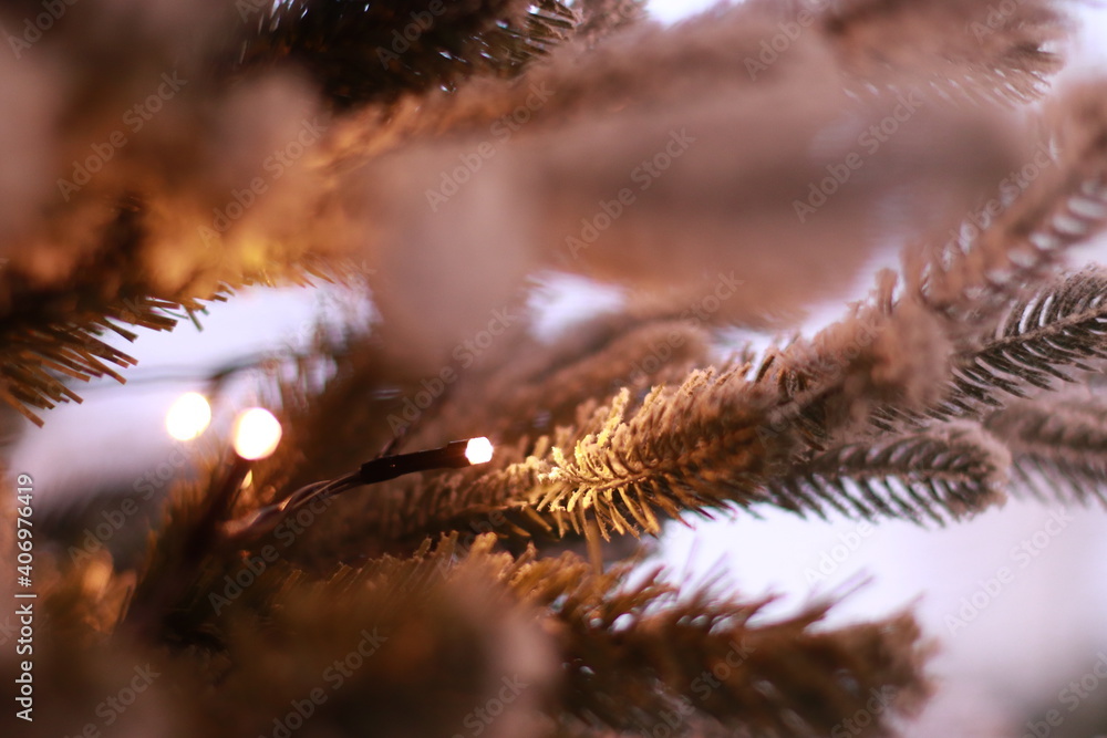 an artificial green spruce branch with garlands stands in the room and flashes a warm white light an artificial green spruce branch with garlands stands in the room and flashes a warm white light