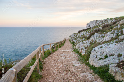 path that descends along the cliff with calm sea during the sunset on the coast of Otranto  Puglia  Italy.