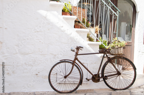vintage bike resting against the wall in the white town of Ostuni in Apulia. Italian Lifestyle #406978070